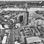 Vista aérea em preto e branco da marina de Southampton, com barcos atracados e a área urbana à margem da água.