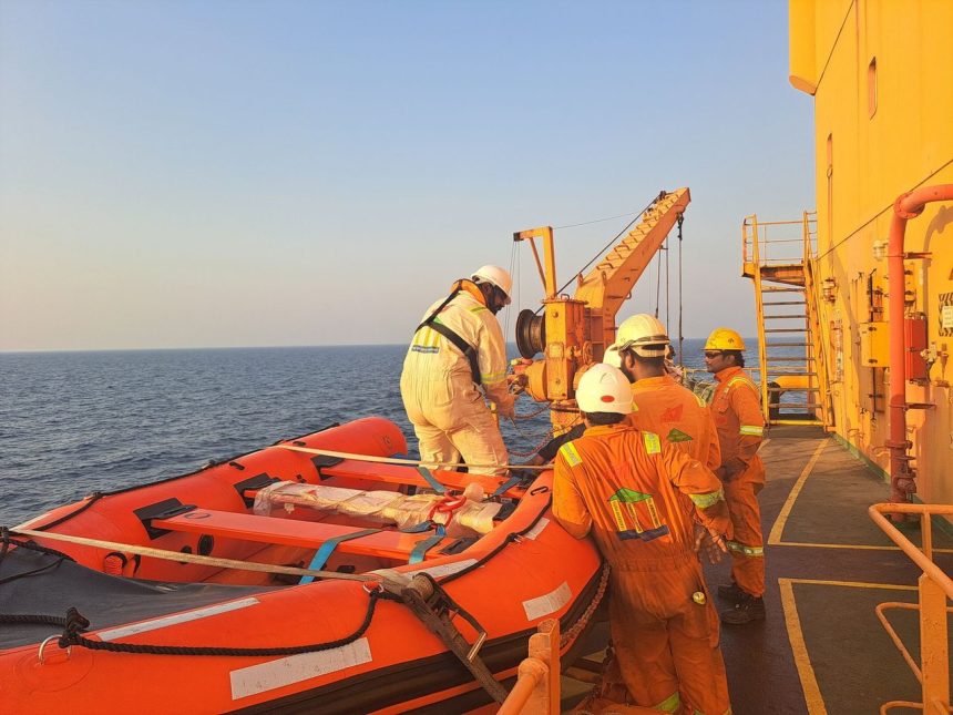 Tripulantes usando equipamentos de proteção preparam um bote salva-vidas durante um exercício de segurança marítima a bordo de um navio.