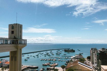 Vista do porto de Salvador com embarcações e o Elevador Lacerda ao fundo.