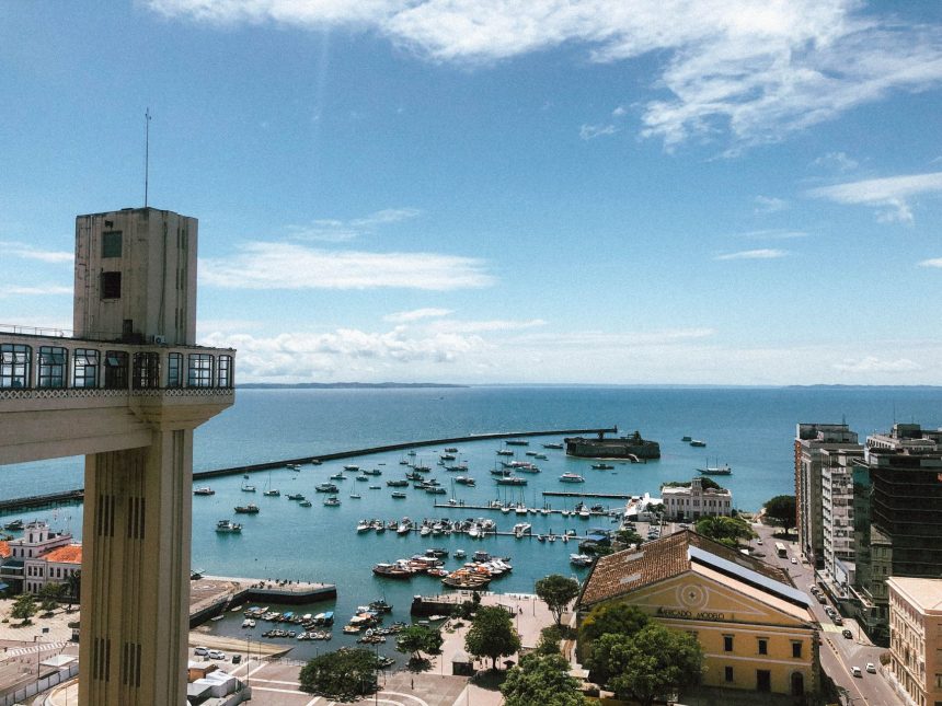 Vista do porto de Salvador com embarcações e o Elevador Lacerda ao fundo.